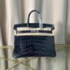 leu Indigo Shiny Niloticus Crocodile Birkin 25 Bag Front view of an artisan luxury Birkin 25 bag in Bleu Indigo shiny Niloticus crocodile leather with palladium hardware