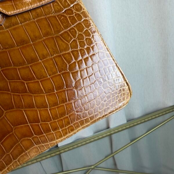 Miel Shiny Niloticus Crocodile Birkin 25 Retourne Gold Hardware Front view of a Birkin 25 bag in Miel shiny Niloticus crocodile leather with gold hardware.