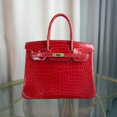 Rose Scheherazade Shiny Porosus Crocodile Birkin 30 Bag Front view of a luxury Birkin 30 bag in Rose Scheherazade shiny Porosus crocodile leather with gold hardware.