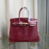 Bordeaux Shiny Niloticus Crocodile Birkin 30 Bag Front view of a luxury Birkin 30 bag in Bordeaux shiny Niloticus crocodile leather with gold hardware.
