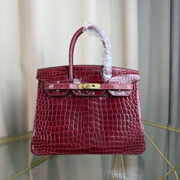 Bordeaux Shiny Niloticus Crocodile Birkin 30 Bag Front view of a luxury Birkin 30 bag in Bordeaux shiny Niloticus crocodile leather with gold hardware.