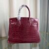Bordeaux Shiny Niloticus Crocodile Birkin 30 Bag Front view of a luxury Birkin 30 bag in Bordeaux shiny Niloticus crocodile leather with gold hardware.