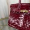Bordeaux Shiny Niloticus Crocodile Birkin 30 Bag Front view of a luxury Birkin 30 bag in Bordeaux shiny Niloticus crocodile leather with gold hardware.