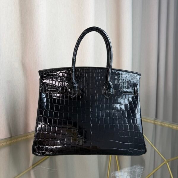 Black Shiny Niloticus Crocodile Birkin 30 Bag Front view of a luxury Birkin 30 bag in Black shiny Niloticus crocodile leather with palladium hardware.