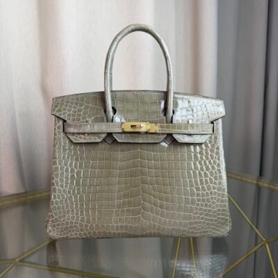 Gris Tourterelle Shiny Porosus Crocodile Birkin 30 Bag Front view of a luxury Birkin 30 bag in Gris Tourterelle shiny Porosus crocodile leather with gold hardware.