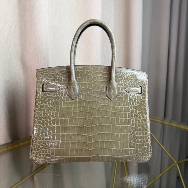 Gris Tourterelle Shiny Porosus Crocodile Birkin 30 Bag Front view of a luxury Birkin 30 bag in Gris Tourterelle shiny Porosus crocodile leather with gold hardware.