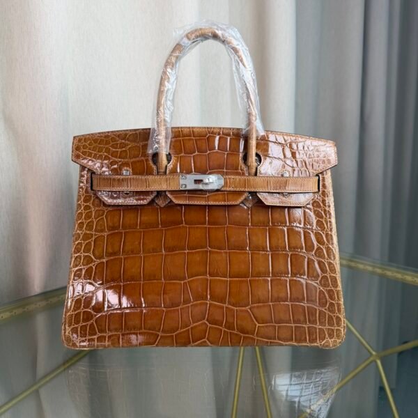 Miel Shiny Niloticus Crocodile Birkin 30 Bag Front view of a luxury Birkin 30 bag in Miel shiny Niloticus crocodile leather with palladium hardware.