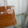 Miel Shiny Niloticus Crocodile Birkin 30 Bag Front view of a luxury Birkin 30 bag in Miel shiny Niloticus crocodile leather with palladium hardware.