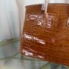 Miel Shiny Niloticus Crocodile Birkin 30 Bag Front view of a luxury Birkin 30 bag in Miel shiny Niloticus crocodile leather with palladium hardware.